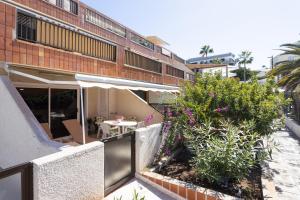 a balcony of a building with a table and flowers at Gigantes Cliff Holiday Home by Sydney Playa Sur in Acantilado de los Gigantes