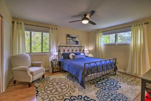 a bedroom with a bed and a chair and windows at Updated Ranch-Style Home with Scenic Deck, Pond in Kingsport