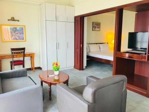 een woonkamer met een bank en een kamer met een bed bij KL Cozy Suite Times Square in Kuala Lumpur
