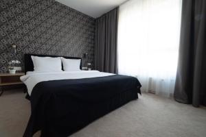 a bedroom with a large bed and a large window at Vitosha Park Hotel - Free Indoor Pool & Parking in Sofia