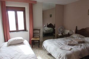 a bedroom with two beds and a window and a mirror at Villa Pico in Sella