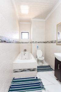 Un baño blanco con bañera y inodoro. en The Hide on kilburn, en Roodepoort 149 fotos más