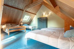 een slaapkamer met 2 bedden op een zolder bij Le Chalet à la Mer in Erdeven