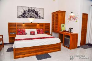 a bedroom with a large bed and a desk at Simoya Nature Park in Dambulla