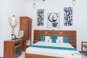 a bedroom with a bed with blue and white pillows at Simoya Nature Park in Dambulla