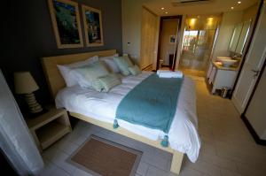 a large bed in a room with a bathroom at Papay Suite by Simply-Seychelles in Eden Island