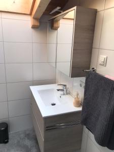 y baño con lavabo blanco y espejo. en Ferienwohnung am Freibad, en Schwarzach