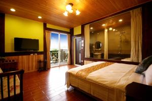 a bedroom with a bed and a television and a balcony at Pulicity Villa B&B in Puli