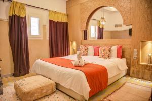 a bedroom with a bed with a rabbit sitting on it at Riad Les Oliviers & Spa in Marrakech