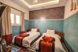 two beds in a room with blue walls at Riad Les Oliviers & Spa in Marrakesh