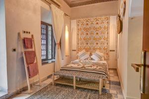 a bedroom with a bed and a window at Riad Les Oliviers & Spa in Marrakesh