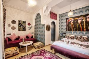 a bedroom with two beds and a couch at Riad Les Oliviers & Spa in Marrakesh