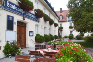 un ristorante con tavolo e sedie di fronte a un edificio di Landgasthof Ostermair a Petershausen