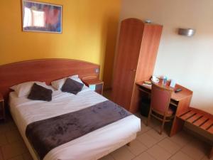ein Hotelzimmer mit einem Bett, einem Schreibtisch und einem Stuhl in der Unterkunft LOGIS Hôtel - Les Paturelles in Avesnelles