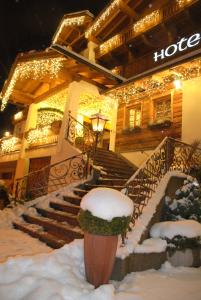 un hôtel avec de la neige sur les escaliers en face de celui-ci dans l'établissement Sporthotel Cristall, à Fulpmes