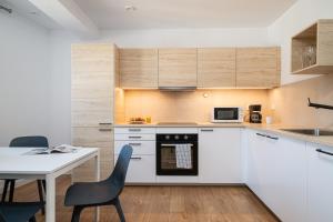 a kitchen with white cabinets and a table with chairs at LeoApart in Wrocław