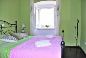 a green bedroom with a pink bed with a window at Villa Tony in Orasac