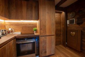 a kitchen with wooden walls and a stove and a refrigerator at L.A. SUITE Courmayeur in Courmayeur