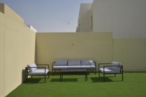 bnbmehomes - Elegant 3 BR - Dubai South - G04 في دبي: ثلاثة كراسي ومقعد في مبنى