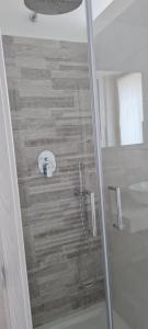 y baño con ducha y puerta de cristal. en Elements B&B, en Azzano San Paolo
