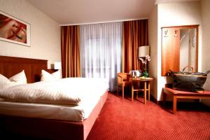 a hotel room with a bed and a desk at Hotel Wegener in Mannheim