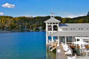 un muelle con un edificio sobre una masa de agua en Werzers Hotel Resort Pörtschach, en Pörtschach am Wörthersee