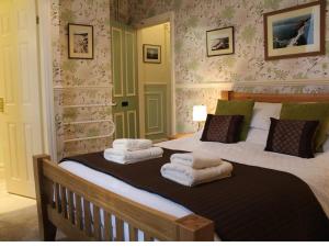 een slaapkamer met een groot bed en handdoeken bij Athol House in Filey