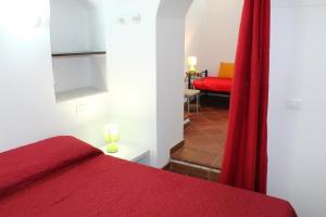ein Schlafzimmer mit einem roten Bett und einem roten Sofa in der Unterkunft L'Arco in Terrasini