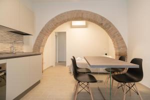 - une cuisine et une salle à manger avec une table et des chaises dans l'établissement Assisium Appartamenti, à Bastia Umbra
