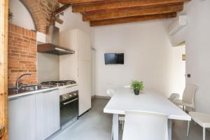 eine Küche mit einer weißen Theke und einem Tisch in der Unterkunft UFFIZI Suite I in Florence-hosted by Sweetstay in Florenz