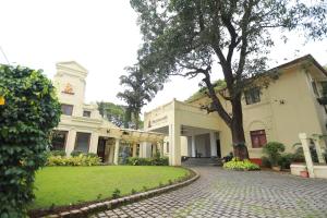 um edifício com uma árvore no meio de uma entrada em Amritara The Poovath Beachfront Heritage, Fort Kochi em Cochin