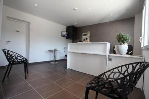 a living room with two chairs and a counter at Hôtel Restaurant les Pielettes in Le Rove