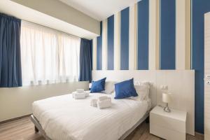 una camera da letto con un grande letto a strisce blu e gialle di IL CONTE Piazza Signoria-Hosted by Sweetstay a Firenze