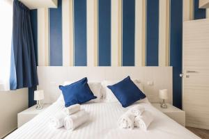 una camera da letto con un letto bianco a strisce blu e gialle di IL CONTE Piazza Signoria-Hosted by Sweetstay a Firenze