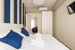 una camera da letto con un grande letto bianco con cuscini blu di IL CONTE Piazza Signoria-Hosted by Sweetstay a Firenze