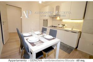 a white dining room table with chairs and a kitchen at Casa Ale GR in Genoa