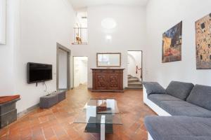 a living room with a couch and a tv at Pontevecchio Luxury Suite AMAZING LOCATION - hosted by Sweetstay in Florence