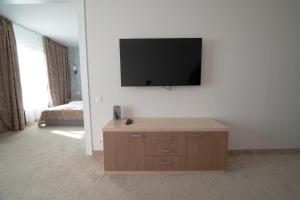 a living room with a television on a wall at Vitosha Park Hotel in Sofia