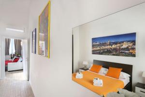 Un dormitorio con una cama con almohadas naranjas. en Granduca Apartment in Top Location, en Florencia