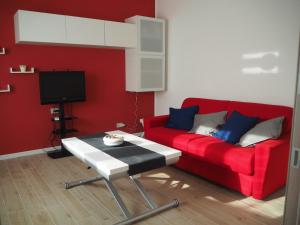 een woonkamer met een rode bank en een tafel bij Victoria House Venice in Mestre