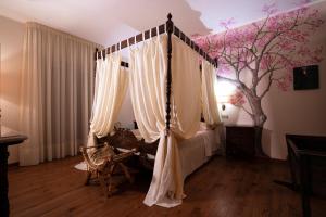 ジノーザにあるVilla D'Anzi B&Bのベッドルーム1室(天蓋付きベッド1台、木の壁画付)