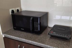 a microwave sitting on top of a kitchen counter at Tata Housing Rio De Goa in Marmagao