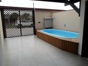 a hot tub in a room with a sliding glass door at LINDO SOBRADO A 250mts DA PRAIA MARISCAL PISCINA 249-3 in Bombinhas