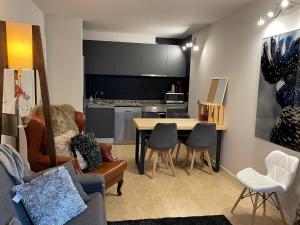 ein Wohnzimmer mit einem Tisch und Stühlen sowie eine Küche in der Unterkunft Puro Centro in Escaldes-Engordany