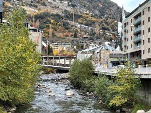 un ponte su un fiume in una città con edifici di Puro Centro a Escaldes-Engordany