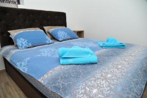 un letto con lenzuola blu e asciugamani blu sopra di Apartmani Krstojević Kopaonik a Kopaonik