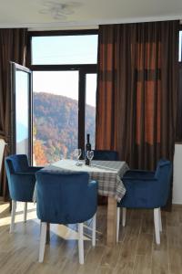 a dining room with a table and chairs and a large window at Apartmani Krstojević Kopaonik in Kopaonik