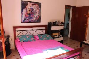 a bedroom with a pink bed with two pillows at Lovely cottage with garden !!!!! in Kariá