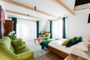 a bedroom with a large bed and two green chairs at Zakopane Apartamenty 4 Seasons in Zakopane