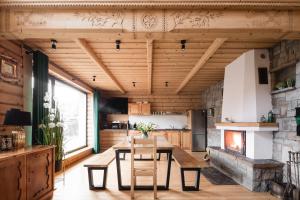 a living room with a table and a fireplace at Zakopane Apartamenty 4 Seasons in Zakopane
